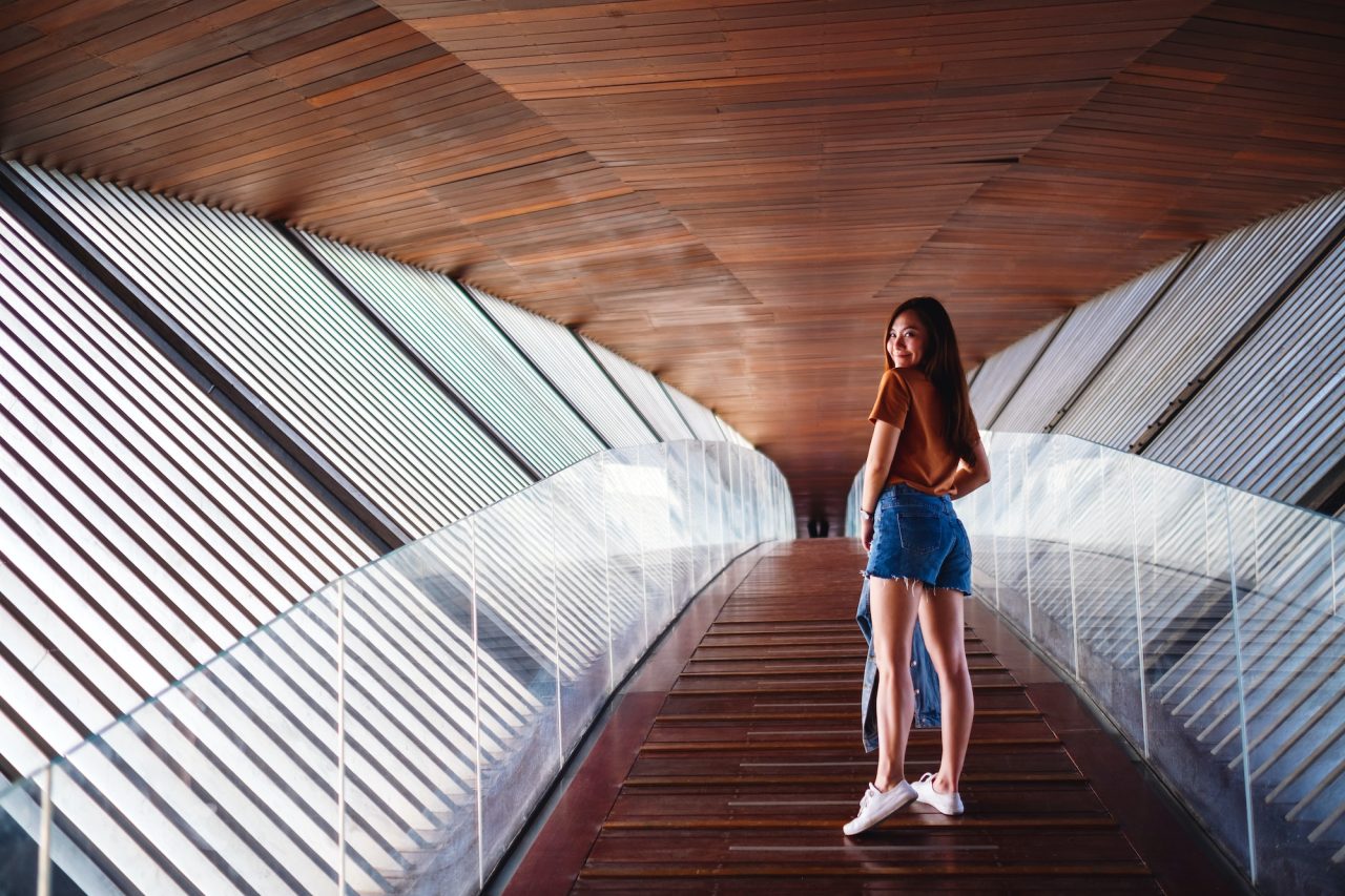 a-young-asian-woman-walking-inside-a-modern-wooden-building.jpg